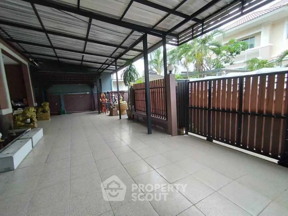 Spacious covered outdoor area with tiled flooring and modern fencing in a residential property.
