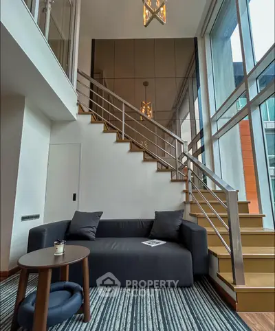 Stylish modern living room with high ceilings and elegant staircase