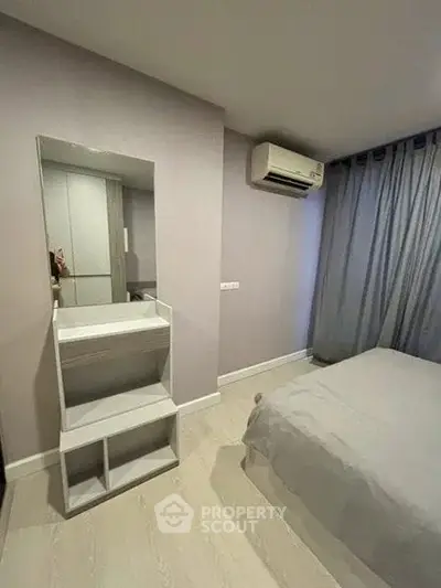 Modern bedroom with air conditioning and minimalist decor, featuring a sleek mirror and cozy bed.