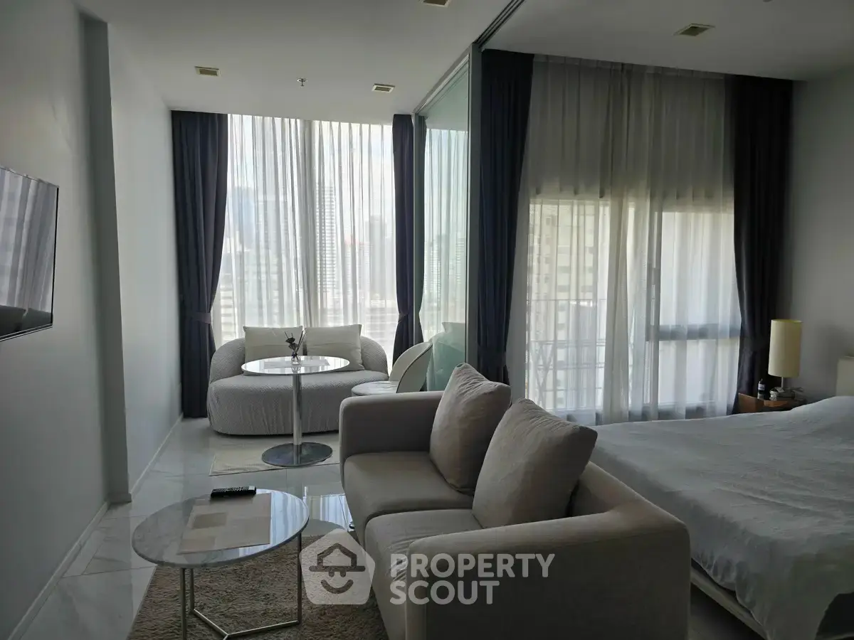 Modern living room with elegant decor and city view, featuring cozy seating and natural light.