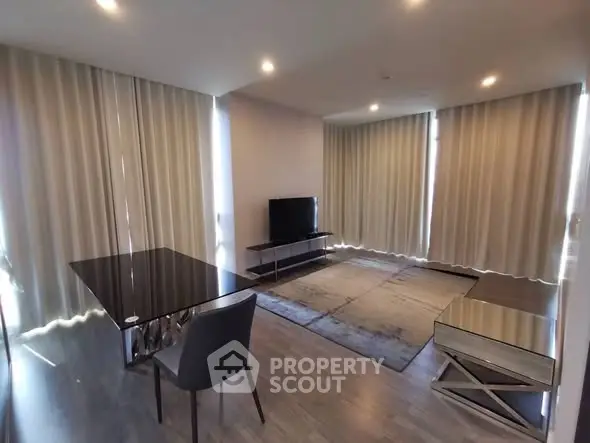 Modern living room with sleek furniture and large windows with curtains