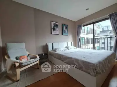 Spacious bedroom with large window and modern decor in urban apartment