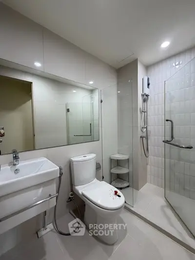 Modern bathroom with glass shower, sleek fixtures, and elegant tile design.
