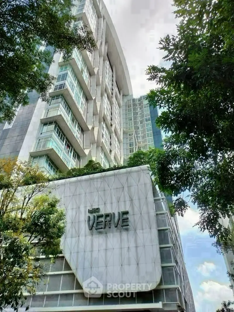 Modern high-rise building with lush greenery and unique architectural design.