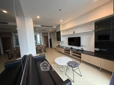 Modern living room with sleek furniture and open layout, featuring a wall-mounted TV and stylish dining area.