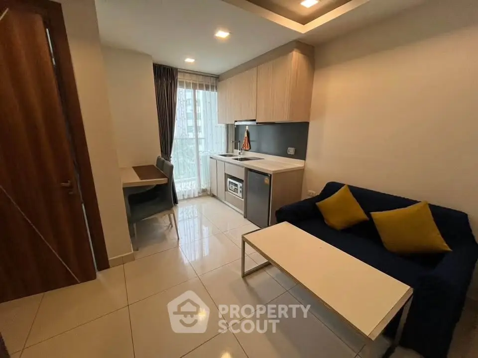 Modern studio apartment with cozy living area and compact kitchen, featuring sleek design and natural light.