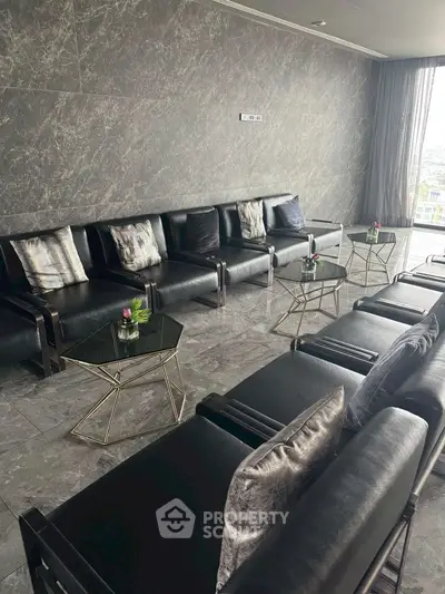 Luxurious modern living room with sleek black leather sofas and elegant glass tables, offering a sophisticated ambiance.