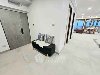 Spacious modern apartment entrance with stylish decor and ocean view living area.