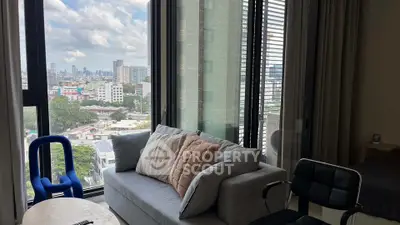 Modern living room with city view, stylish furniture, and large windows.