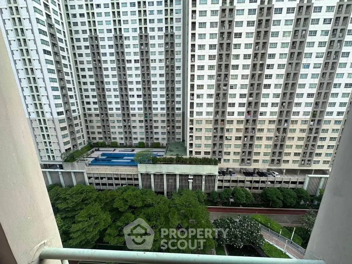 High-rise apartment view with pool and lush greenery