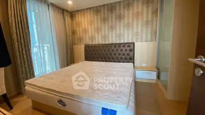 Spacious bedroom with elegant wallpaper and large window for natural light.