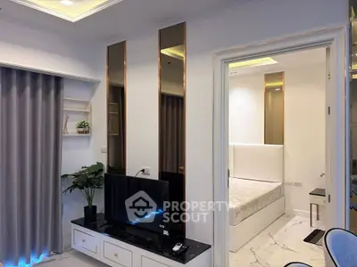 Modern living room with sleek TV setup and cozy bedroom view