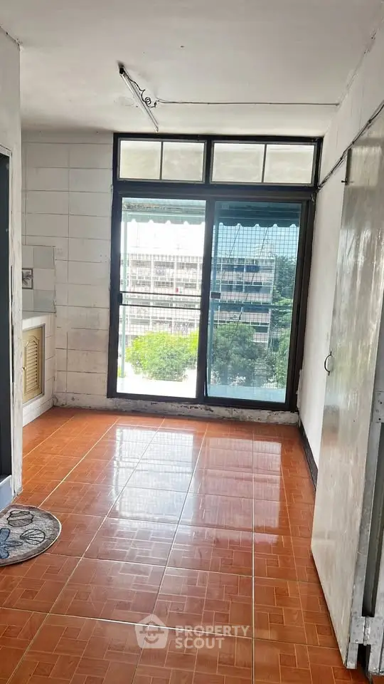 Bright room with large window and tiled floor offering city view, ideal for renovation.
