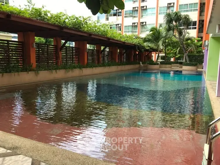 Luxurious residential pool area with lush greenery and modern design, perfect for relaxation and leisure.