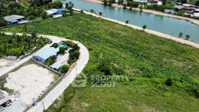 Scenic aerial view of lush green land by a tranquil river, ideal for development opportunities.