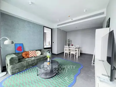 Modern living room with stylish decor and dining area, featuring a cozy sofa and sleek TV setup.