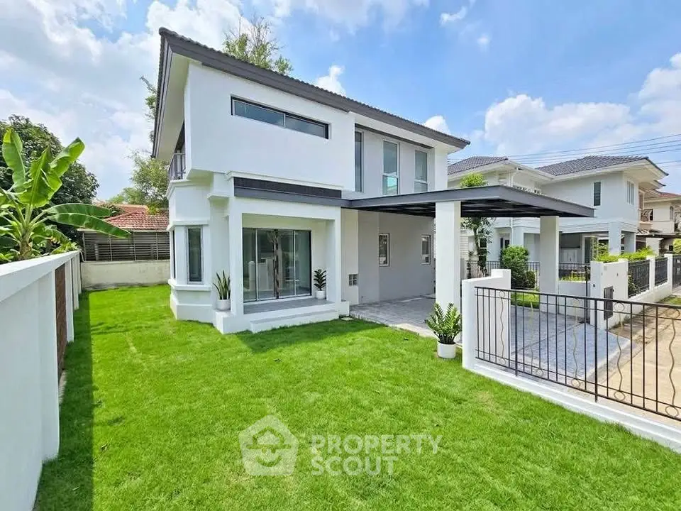 Modern two-story house with lush green lawn and sleek exterior design.