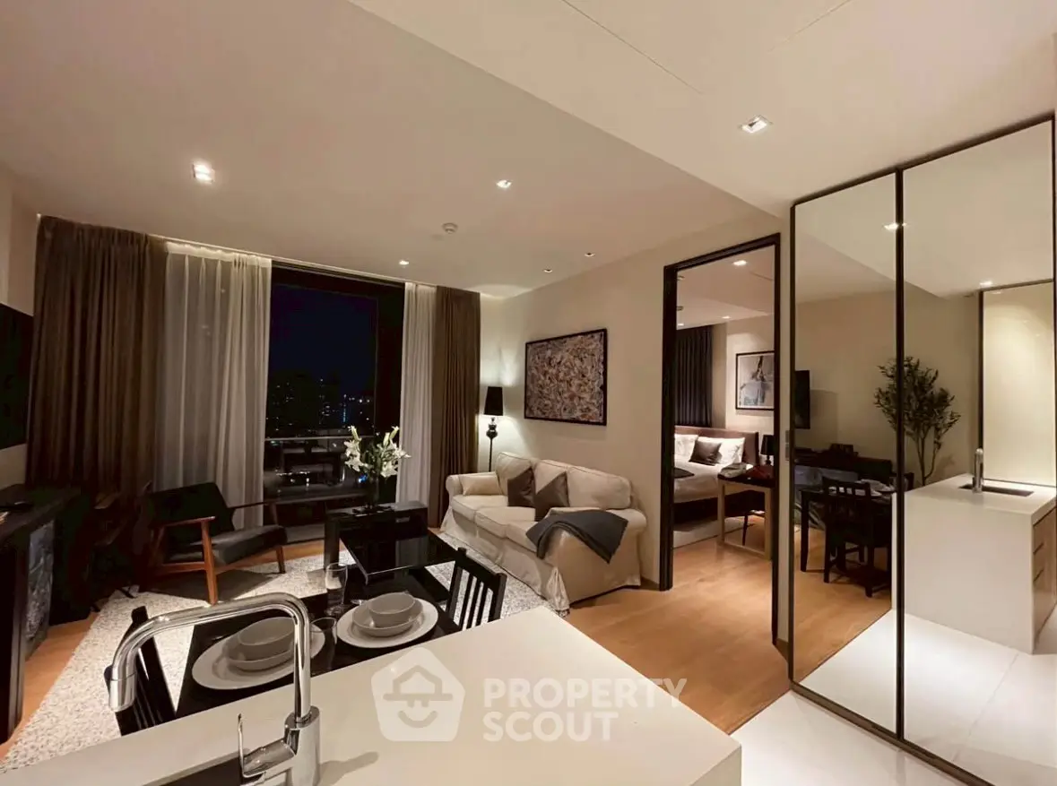 Modern open-plan living room with kitchen and dining area, featuring elegant decor and city view.