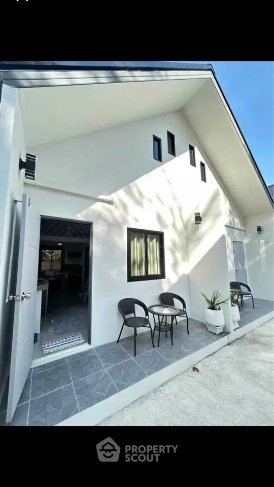 Charming modern home exterior with inviting patio and sleek architectural design.