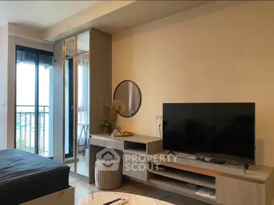 Modern living room with sleek TV unit and balcony view, perfect for urban living.