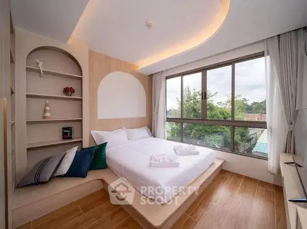 Modern bedroom with large window and built-in shelves, featuring elegant lighting and wooden flooring.