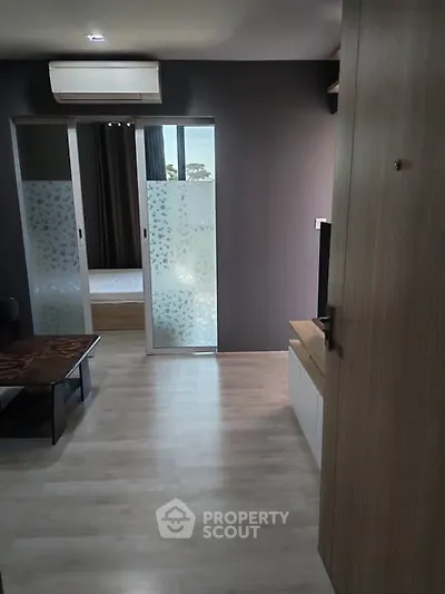 Modern apartment interior with sliding glass doors and wood flooring