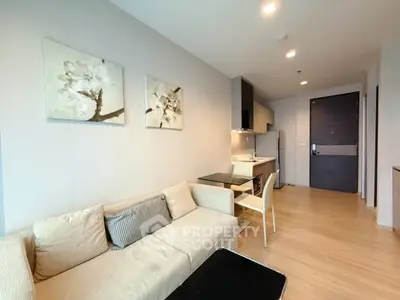 Modern living room with cozy sofa and open kitchen layout in stylish apartment.