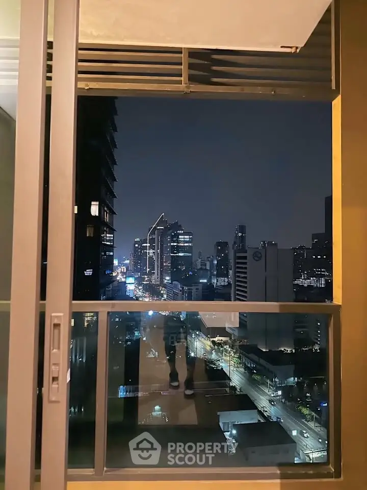 Stunning cityscape view from a modern apartment balcony at night.