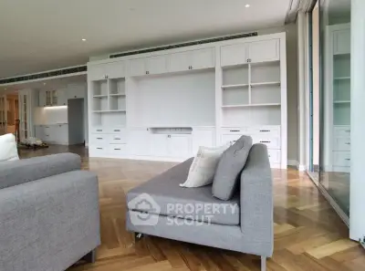 Spacious modern living room with elegant built-in shelving and stylish gray furniture.