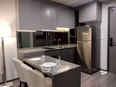Modern kitchen with sleek cabinetry and stainless steel appliances in a stylish apartment.