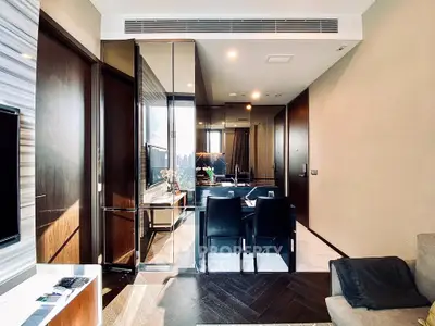 Modern living room with sleek design and dining area, featuring elegant furniture and natural light.