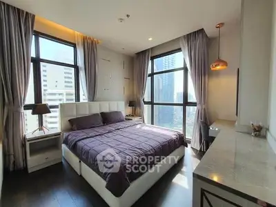 Luxurious bedroom with large windows and city view, modern decor and ample natural light.