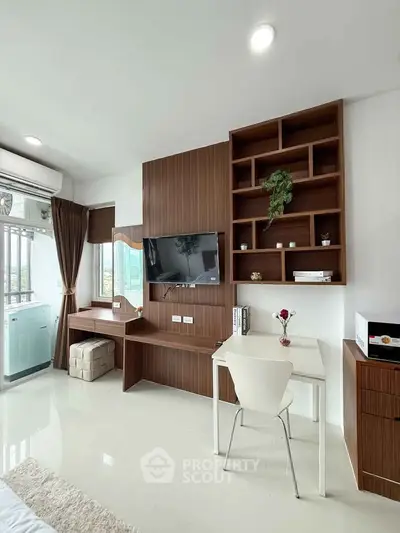 Modern living room with built-in TV unit and study desk, featuring sleek design and natural light.