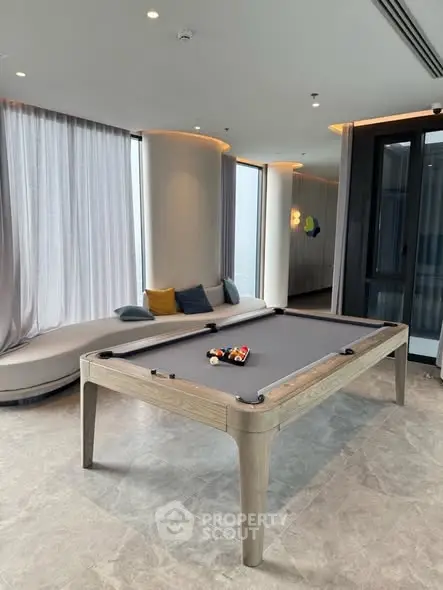 Luxurious modern living room with pool table and elegant seating area, perfect for entertainment.