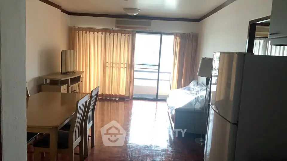 Spacious living room with balcony access and modern furnishings in a bright apartment.