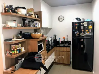 Modern kitchen with sleek black appliances and open shelving for stylish storage solutions.