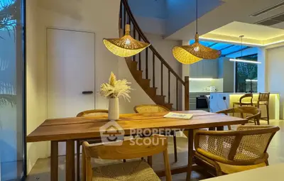 Chic dining area with wooden table, stylish chairs, and modern kitchen in open layout design.