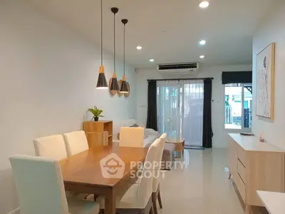Modern dining area with elegant lighting and cozy seating in a stylish home interior.