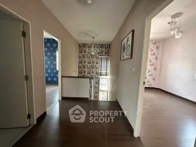 Spacious hallway with wooden flooring and elegant wallpaper, connecting multiple rooms in a modern home.