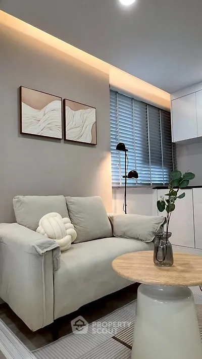 Modern living room with cozy sofa, stylish decor, and natural light from large window.