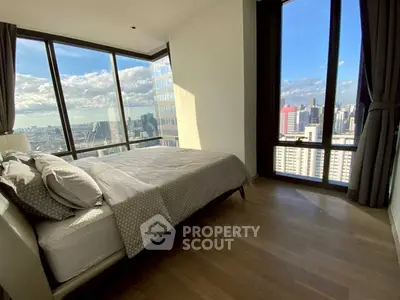 Luxurious bedroom with panoramic city view and floor-to-ceiling windows.