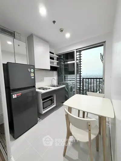Modern compact kitchen with city view, featuring sleek appliances and dining area, perfect for urban living.