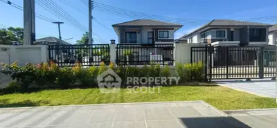 Modern suburban house with gated entrance and landscaped front yard.
