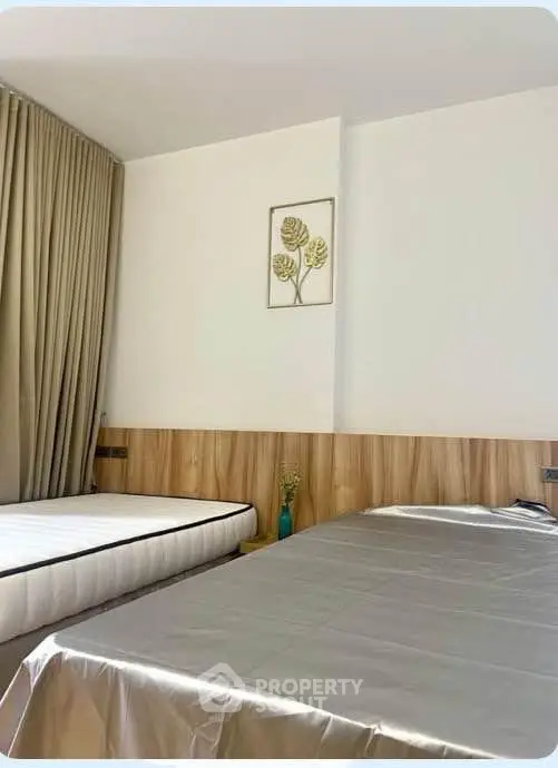 Modern bedroom with stylish decor and natural light, featuring a comfortable bed and elegant wall art.