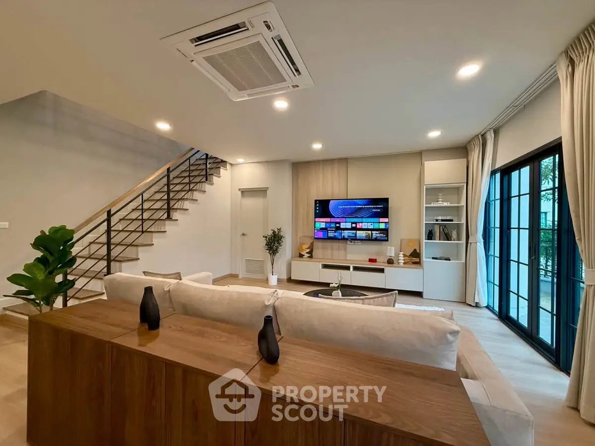 Spacious modern living room with stylish decor and large windows for natural light.
