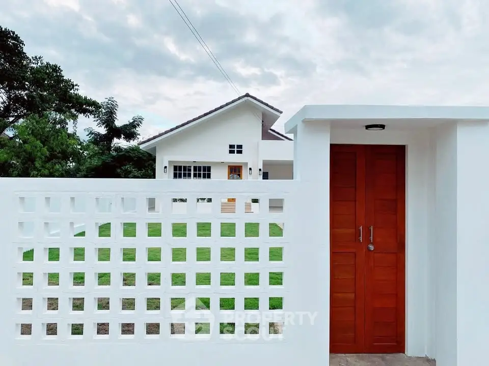 Charming modern house with lush green lawn and stylish wooden gate, perfect for serene living.