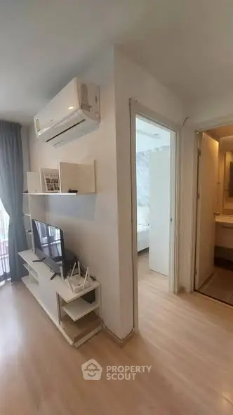 Modern apartment interior with air conditioning, TV, and stylish decor near bedroom and bathroom.