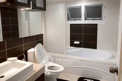 Modern bathroom with sleek design, featuring a bathtub and stylish fixtures.