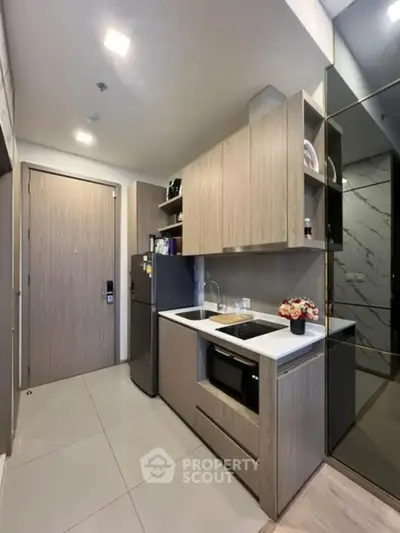 Modern kitchen with sleek cabinetry and built-in appliances in a compact layout.