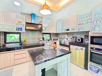 Modern kitchen with island, sleek appliances, and open shelving in a stylish home.